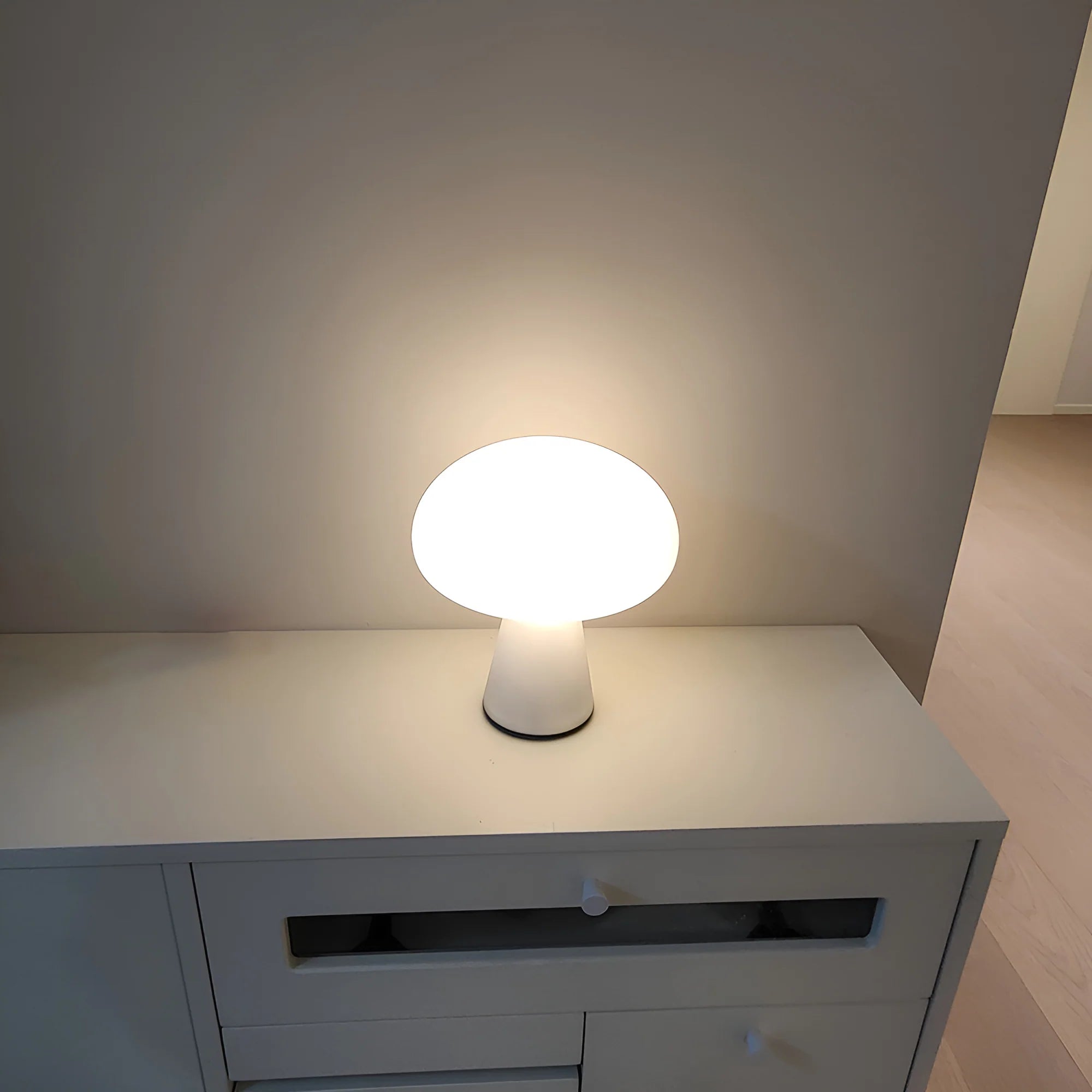 White table lamp on a white surface with a neutral background