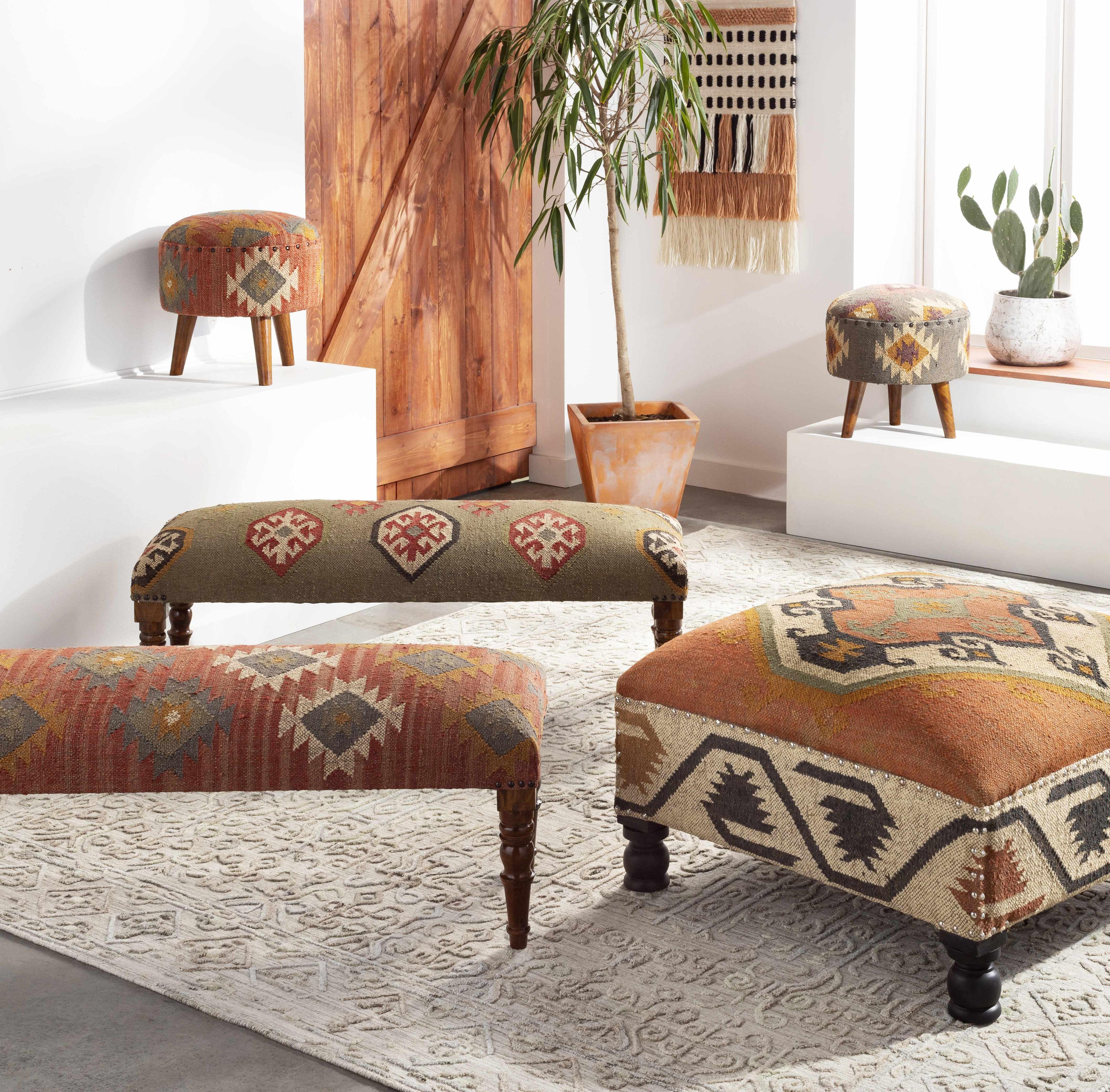 Decorative ottomans with patterned designs in a room with plants and furniture.
