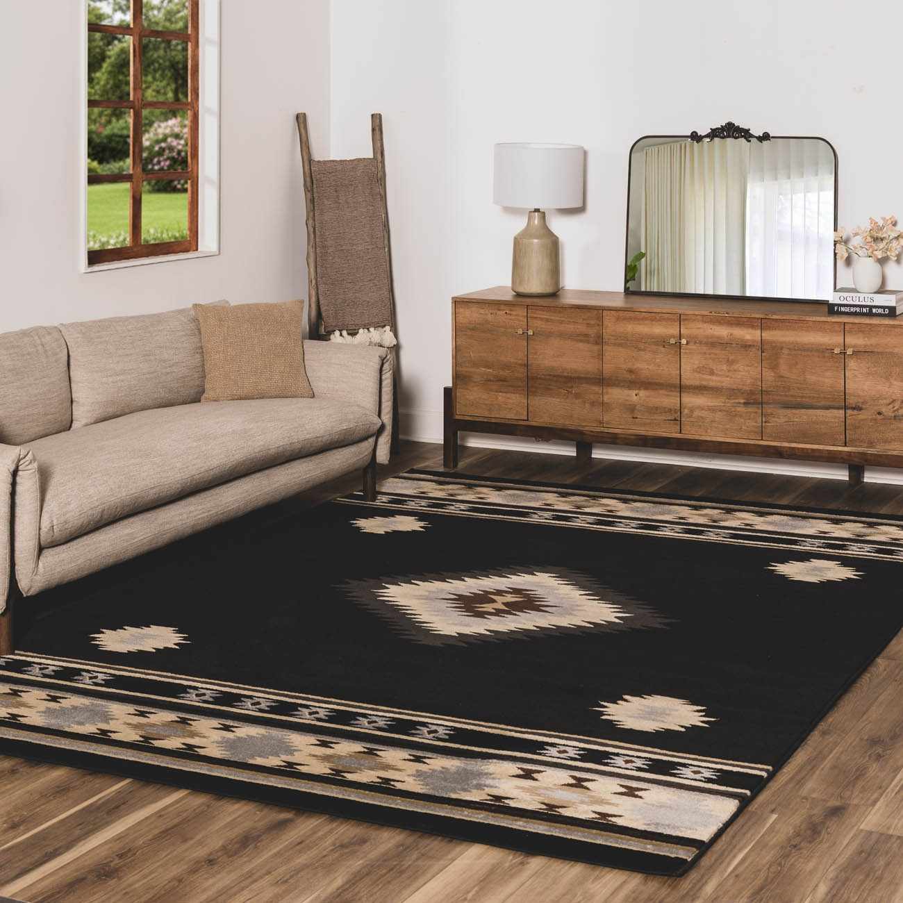 Living room with a black patterned rug, beige sofa, wooden sideboard, and decorative elements.