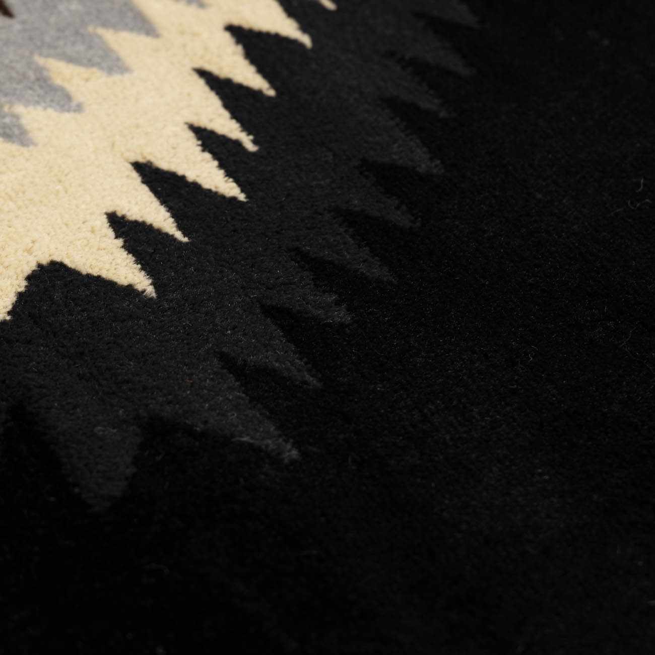 Close-up of a black and beige patterned rug