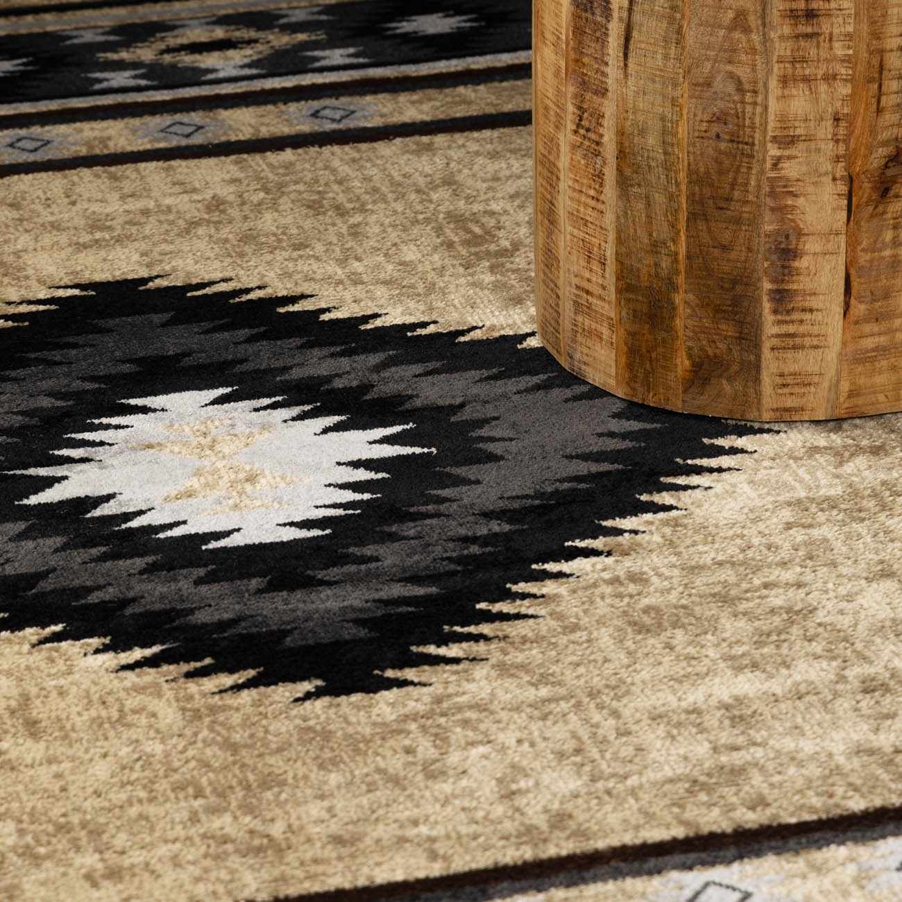 Close-up of a patterned rug with a wooden stool casting a shadow.