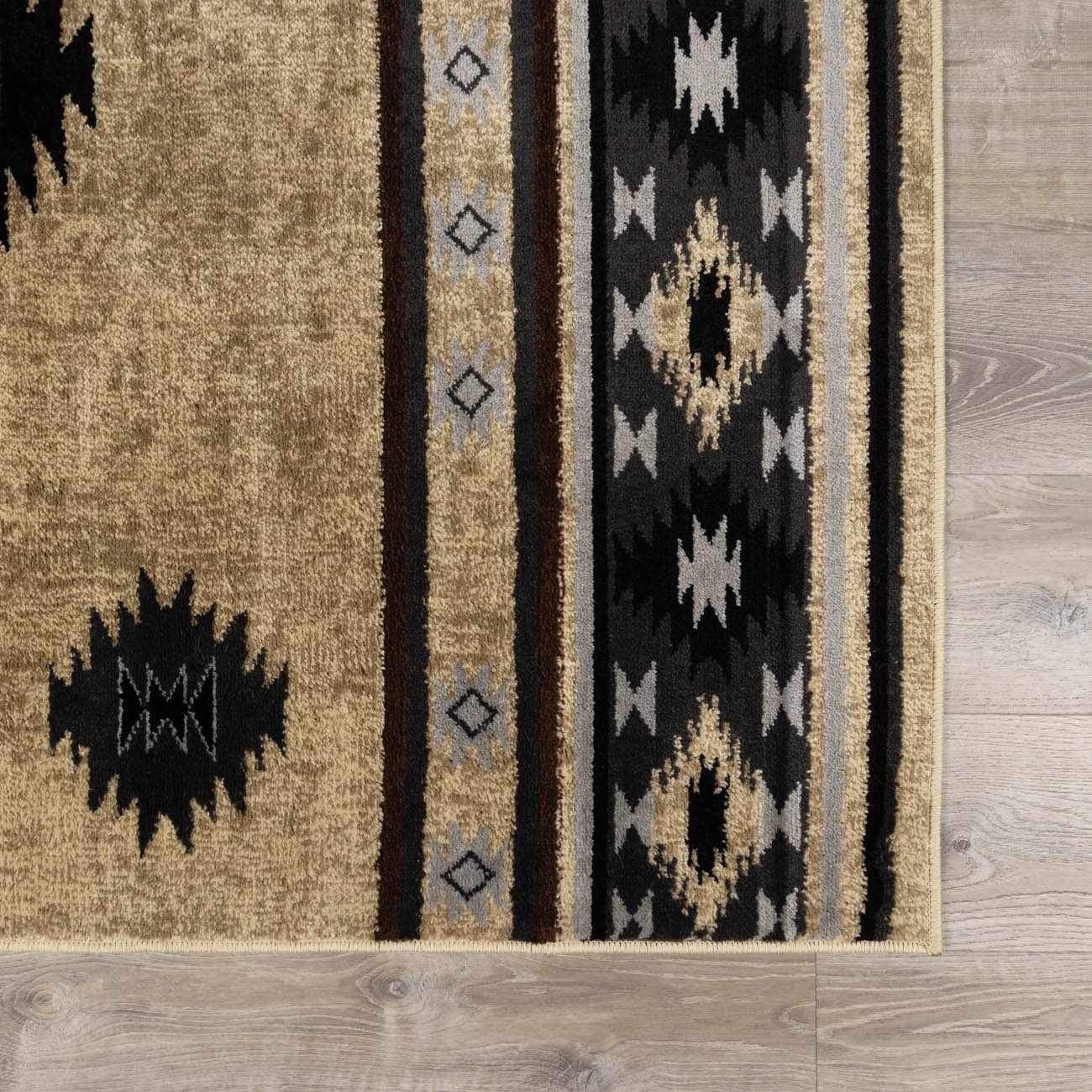 Close-up of a patterned rug with geometric designs on a wooden floor.