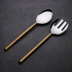 Two spoons with golden handles on a dark gray background