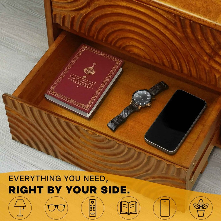 Wooden drawer with a book, watch, and phone on a light wooden floor.
