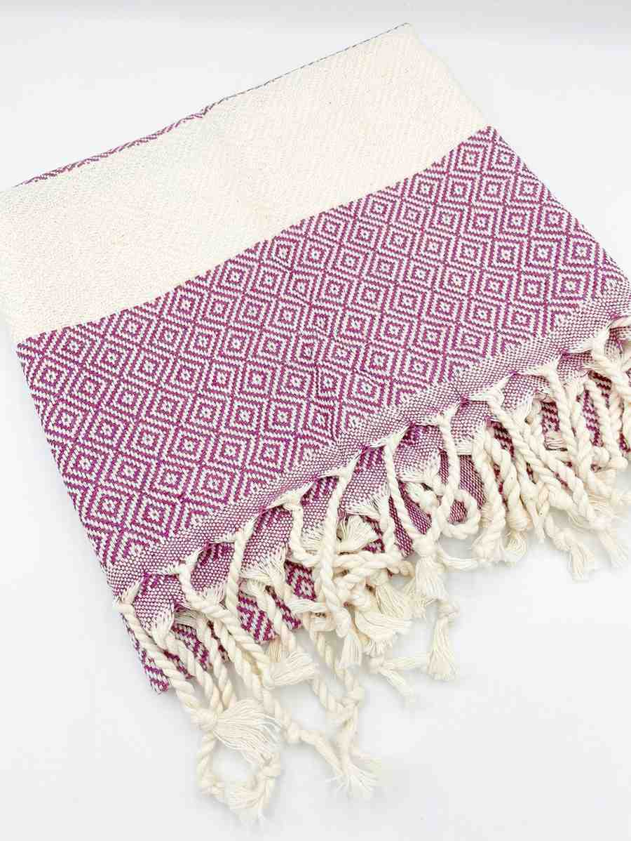 Purple diamond pattern hand towel with white fringe on a white background
