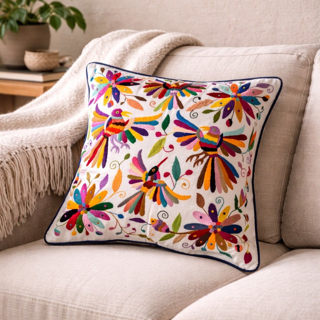 Colorful embroidered pillow on a beige sofa with a neutral background