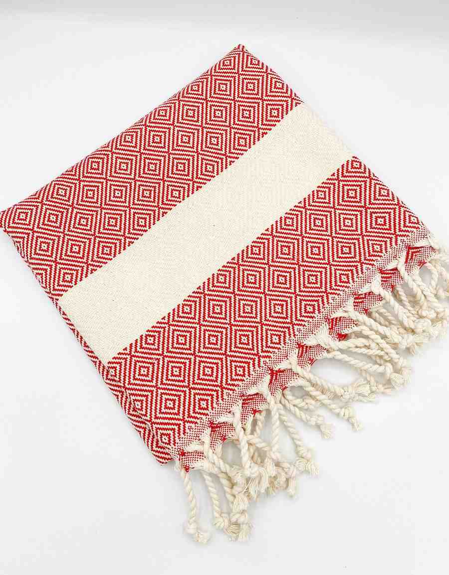 Red diamond pattern hand towel with white stripe and knotted fringe on white background