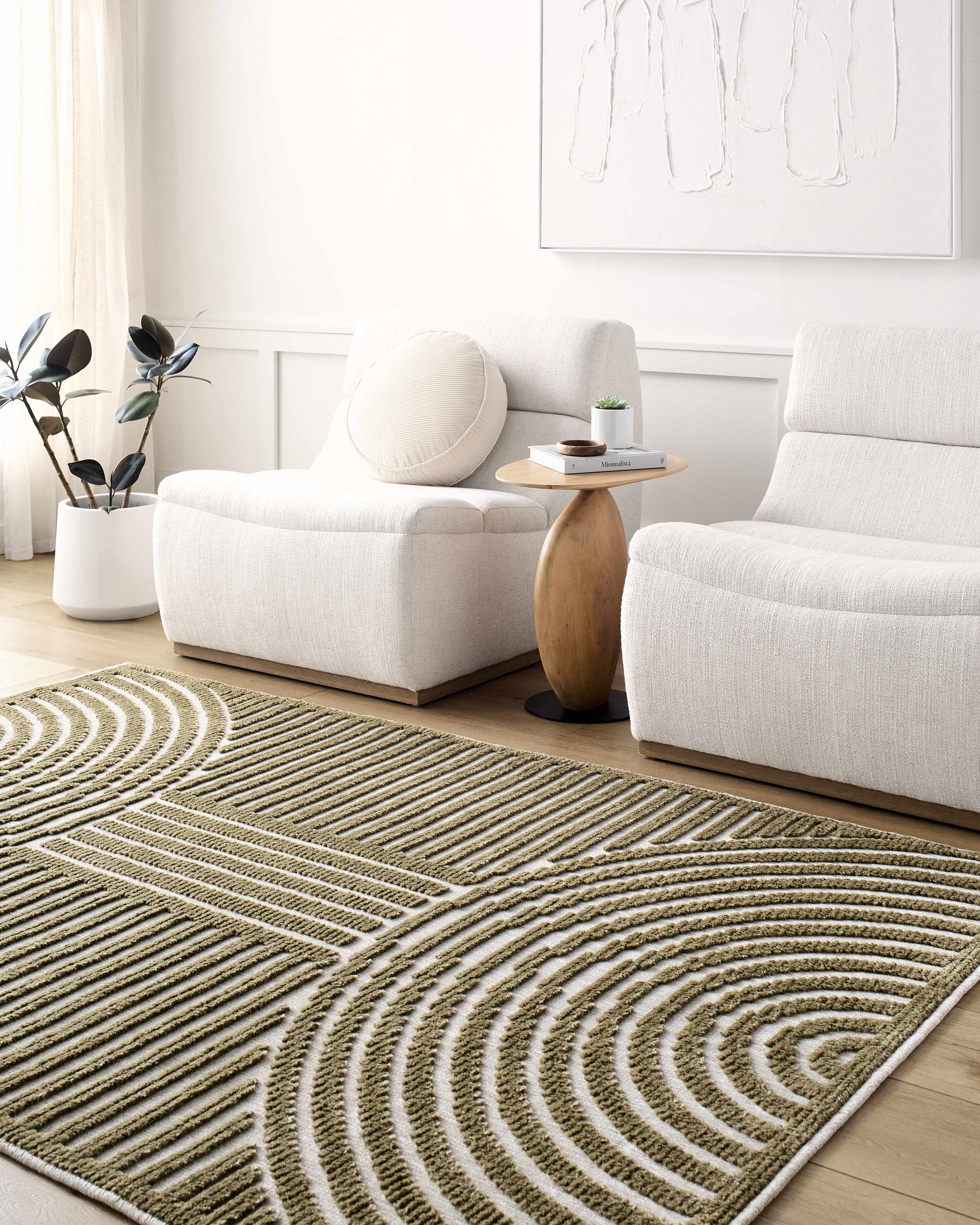 Living room with a textured area rug, white sofa, and abstract wall art.