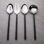 Set of four black-handled silver spoons and fork on a white background