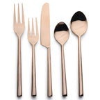 Set of rose gold cutlery including fork, knife, and spoons on a white background