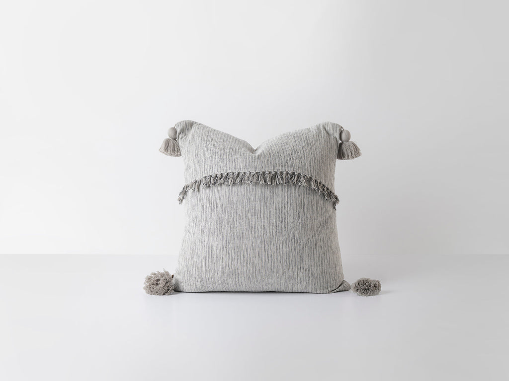 Gray pillow with tassels on a white background