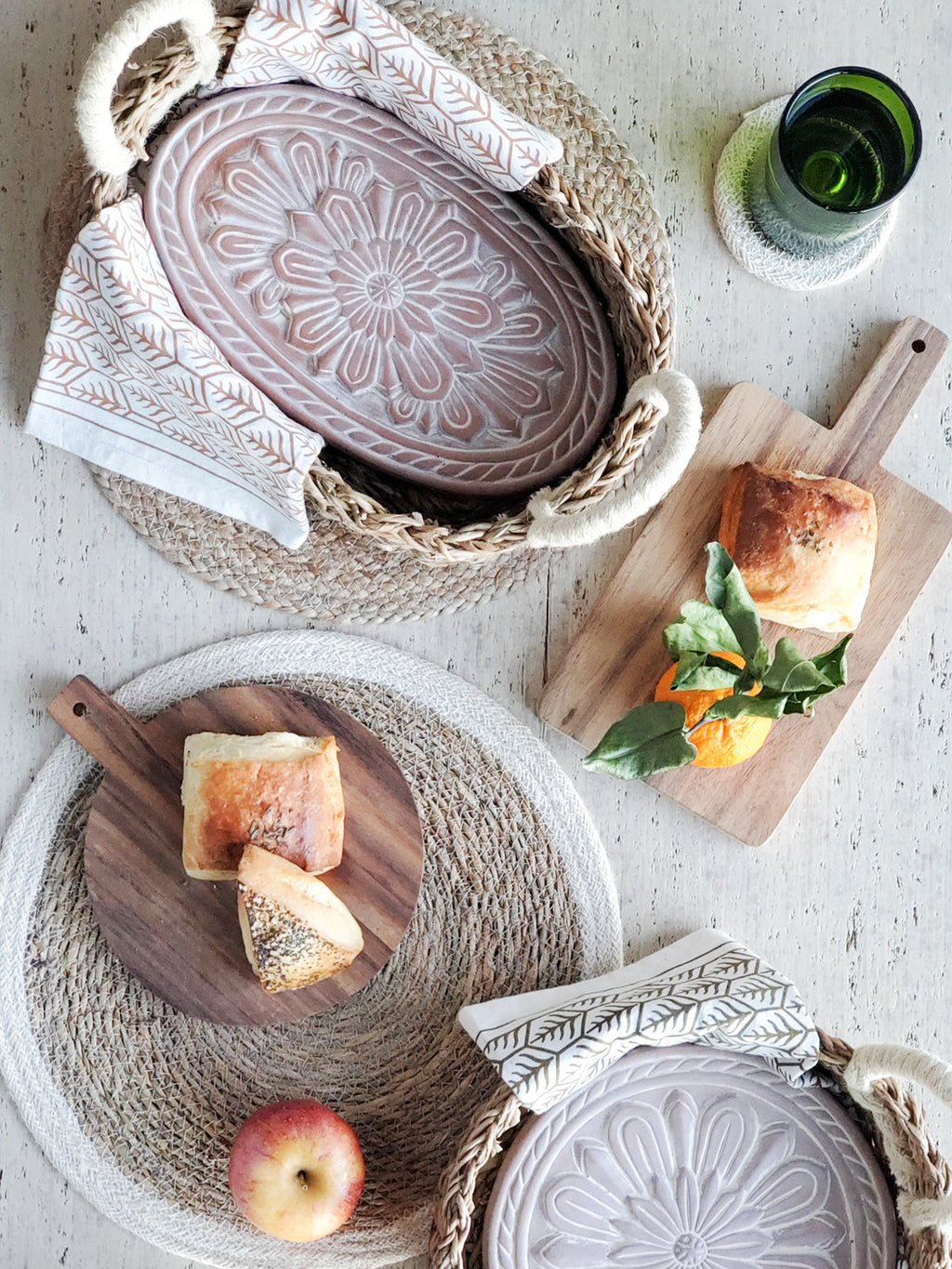 Decorative plates with bread and fruit on a textured surface