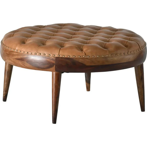 Round brown leather ottoman with wooden legs on a white background