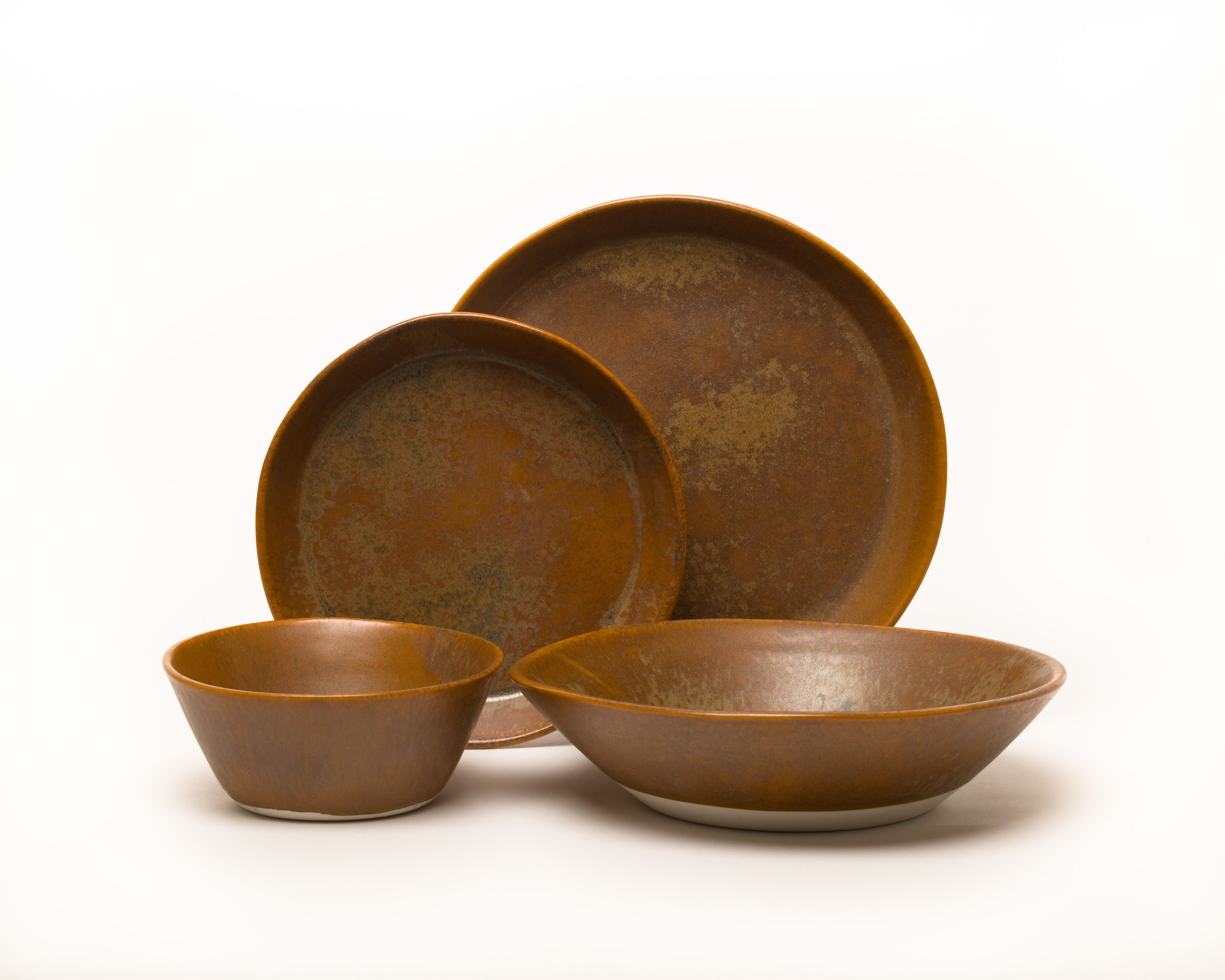 Set of brown ceramic plates and bowls on a white background