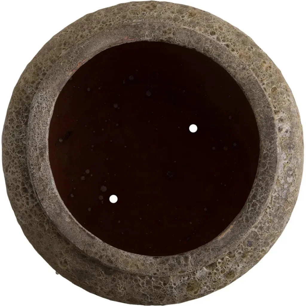 Round stone-like object with a dark center on a white background