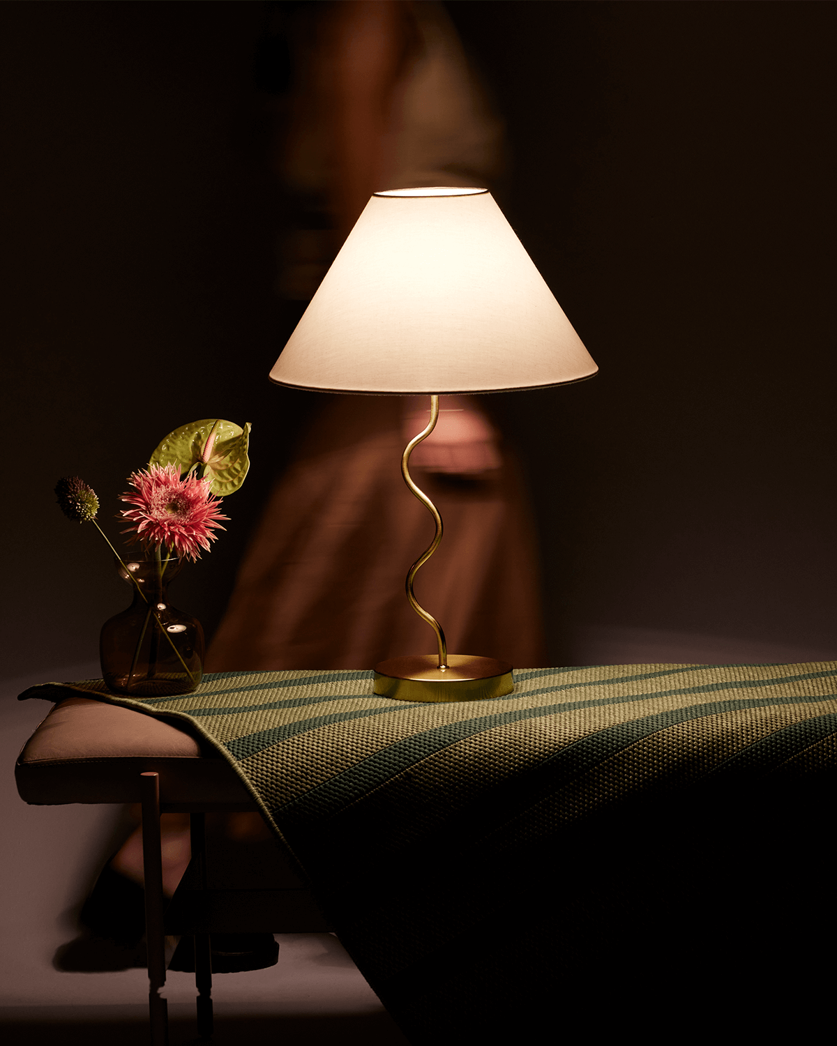 Table lamp with a flower arrangement on a table in a dimly lit room