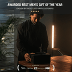 Man opening a black gift box with text about it being 'Awarded Best Men's Gift of the Year'.