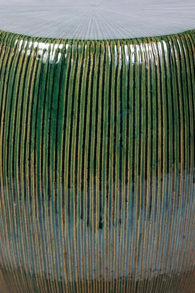 Close-up of a green ceramic stool with ribbed texture