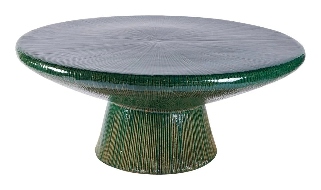Round green ceramic table with textured surface on a white background