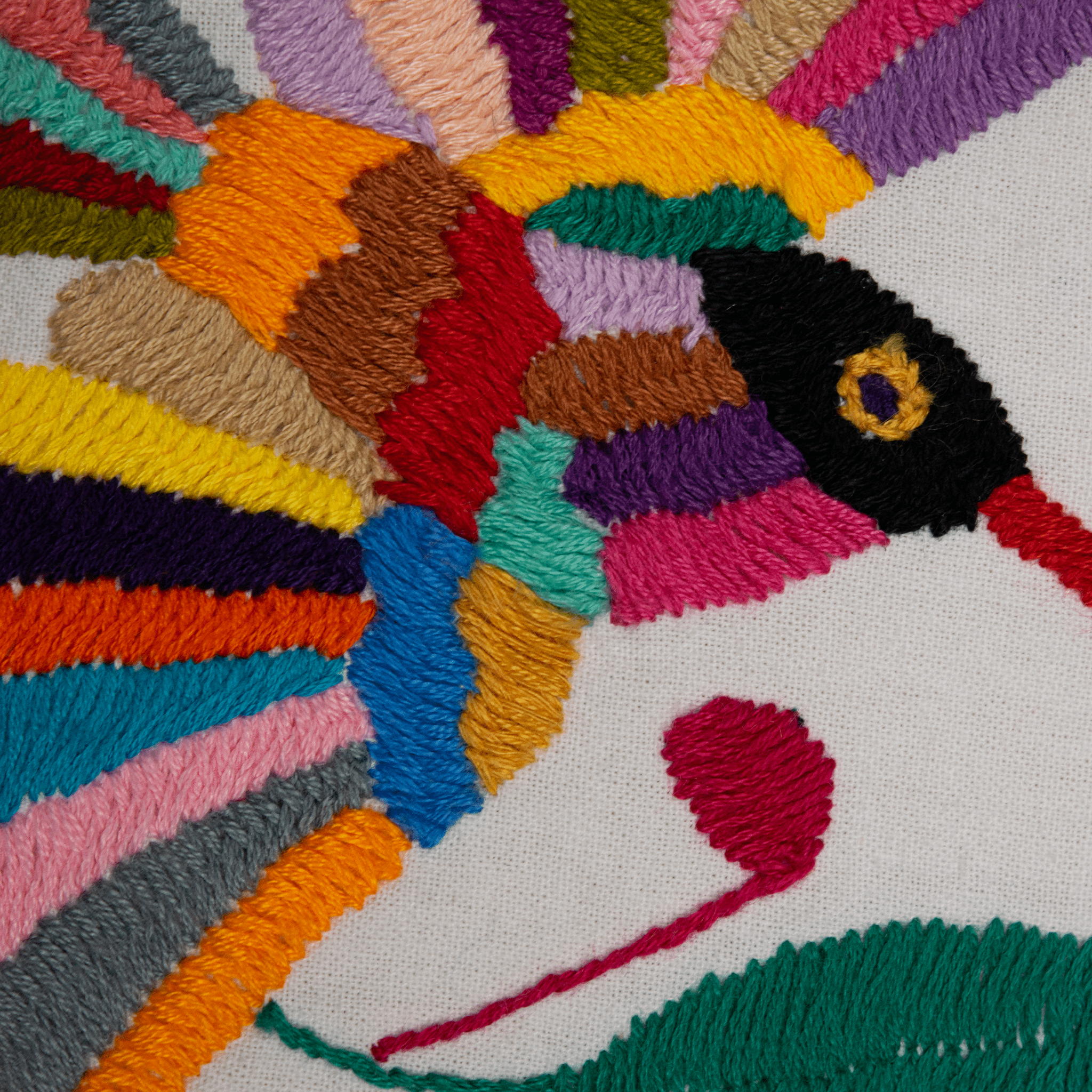 Colorful embroidered fish design on fabric with a white background