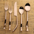 Set of rose gold cutlery on a textured beige background