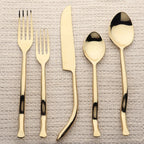 Set of gold cutlery on a textured surface