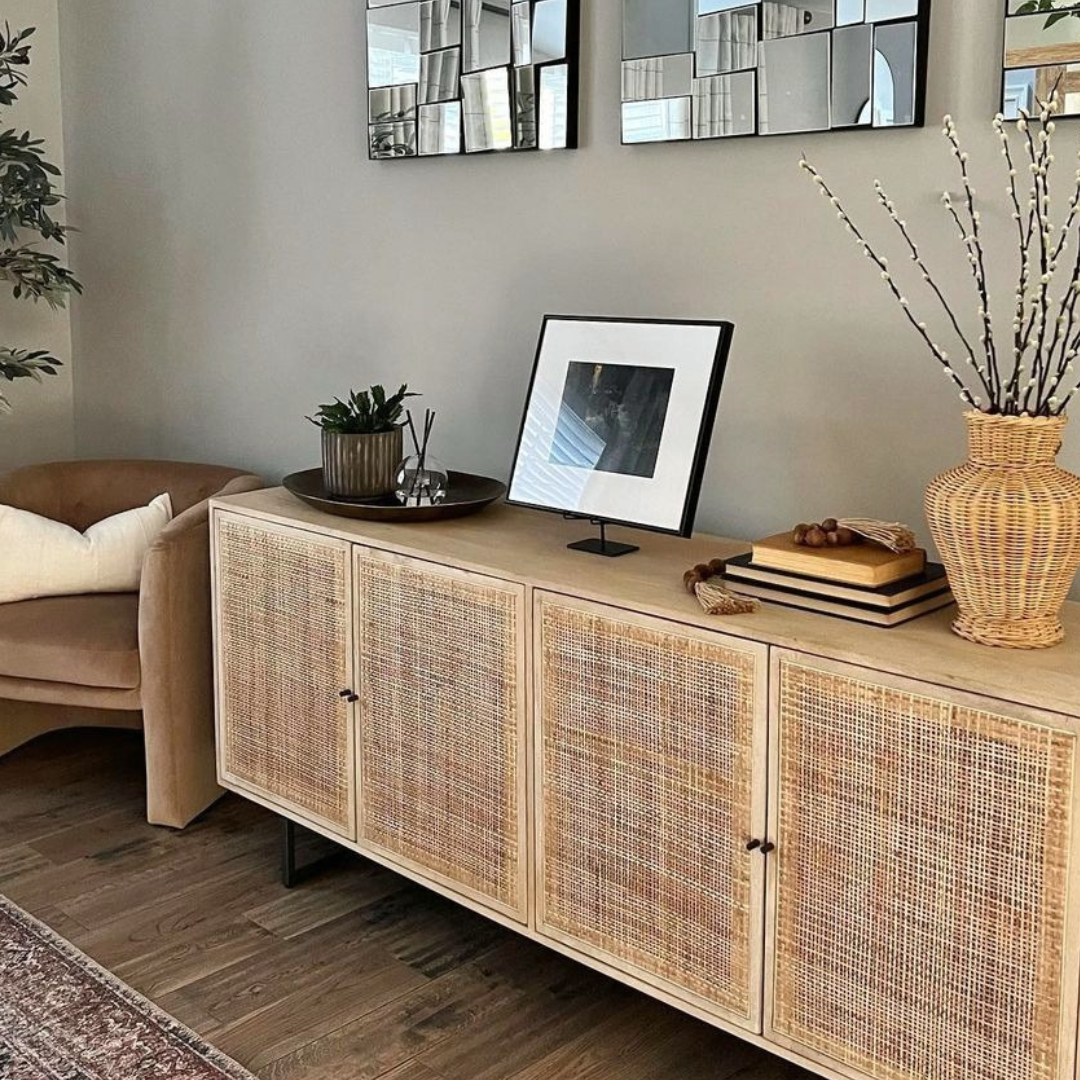 Living room with a wooden sideboard, decorative items, and a mirror on the wall.