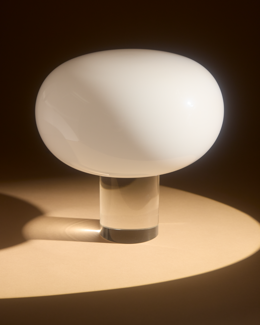 Mushroom-shaped lamp with a clear base on a dark background