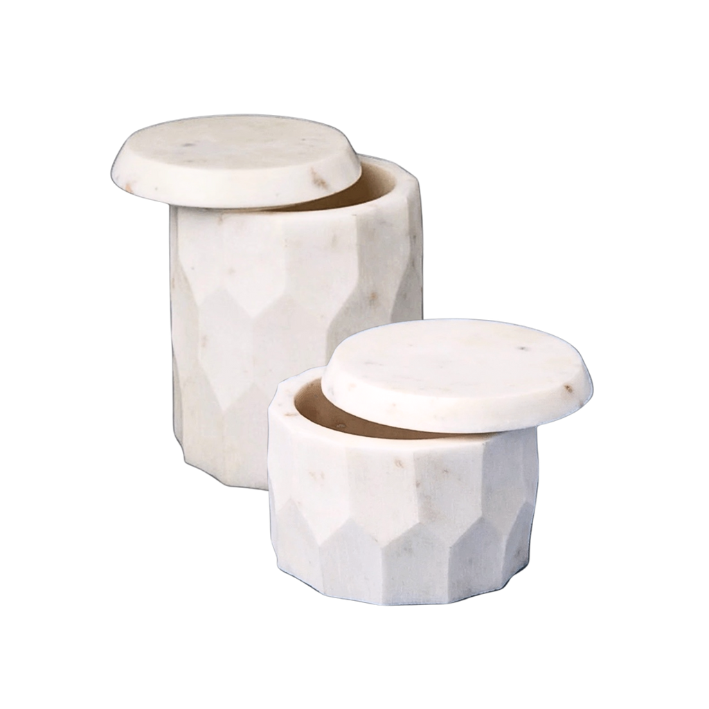 Two marble containers with faceted designs on a white background