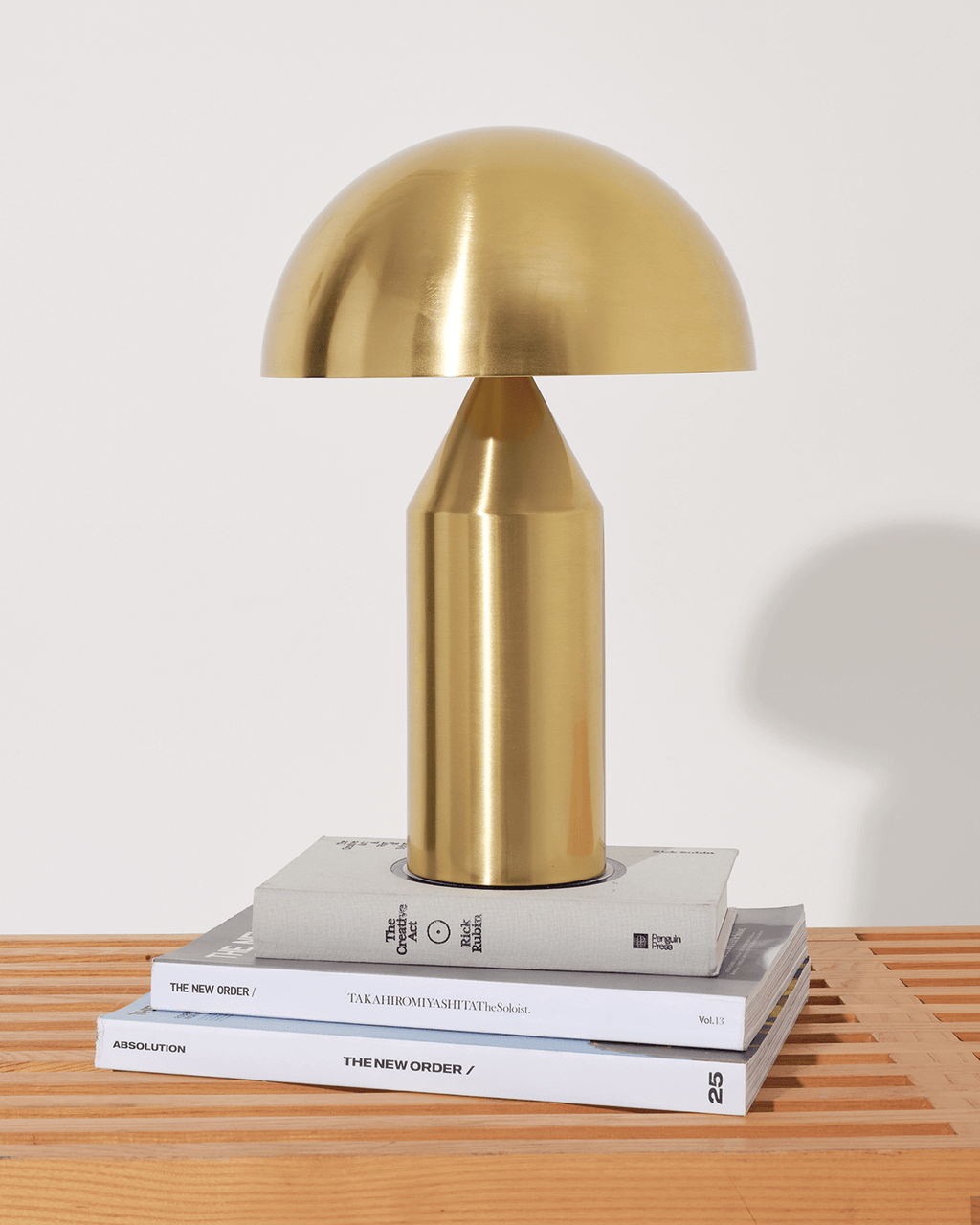 Gold table lamp on a stack of books with a white background