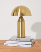 Gold table lamp on a stack of books with a white background
