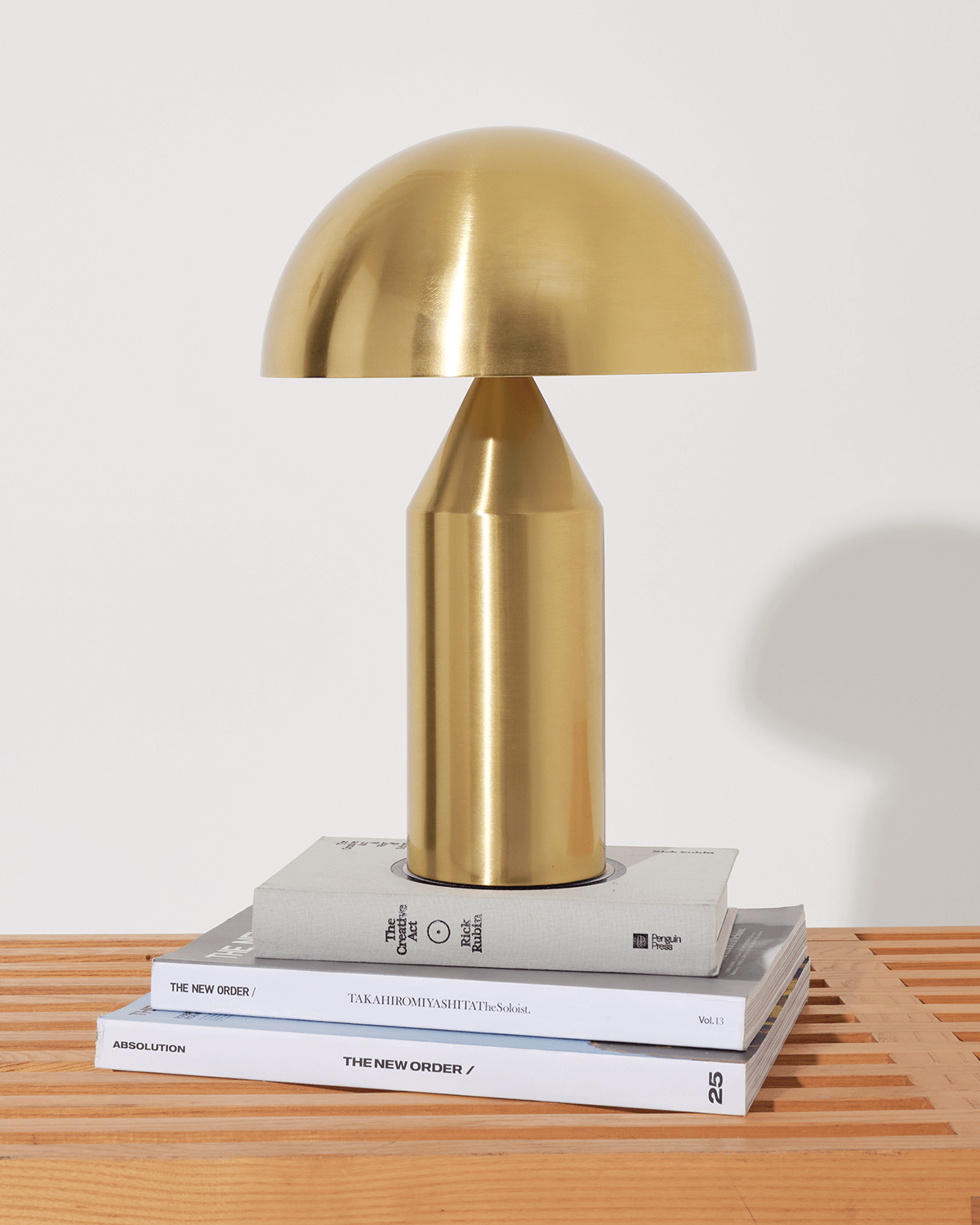 Gold table lamp on a stack of books with a white background