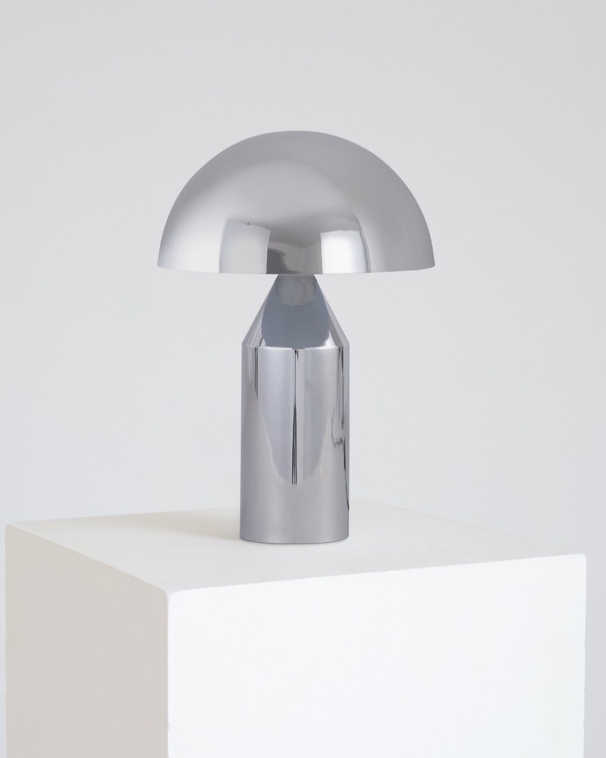 Silver table lamp on a white surface with a light gray background