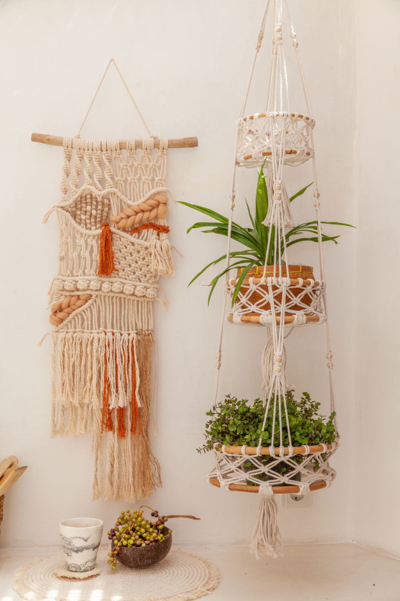 Macrame wall hanging and plant holders on a white wall