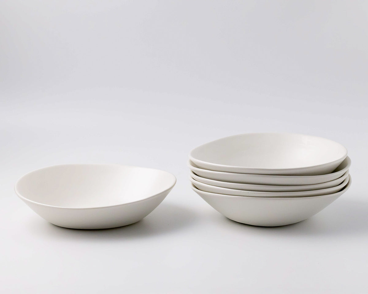 Set of white ceramic bowls on a light gray background