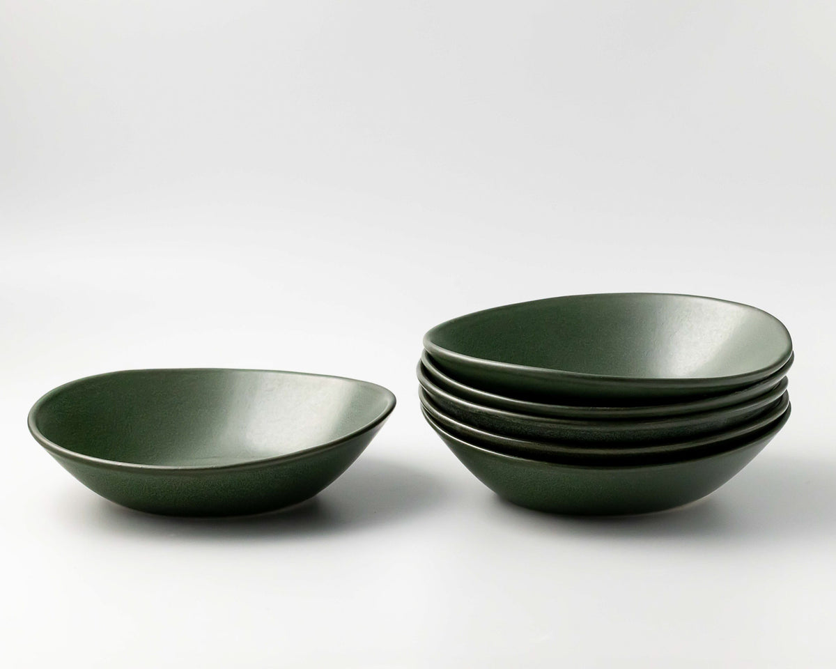 Set of green ceramic bowls on a white background
