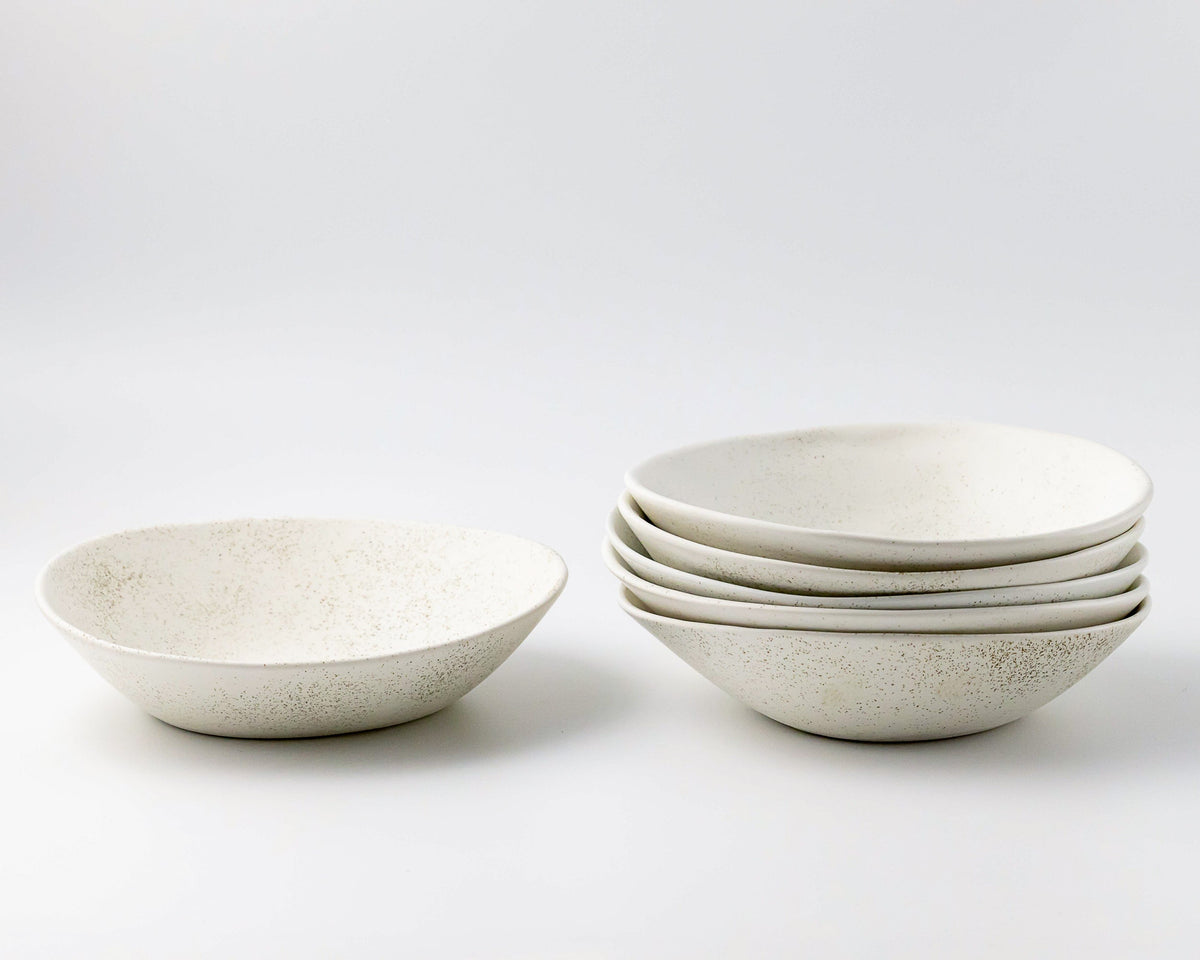 Set of white ceramic bowls on a light gray background