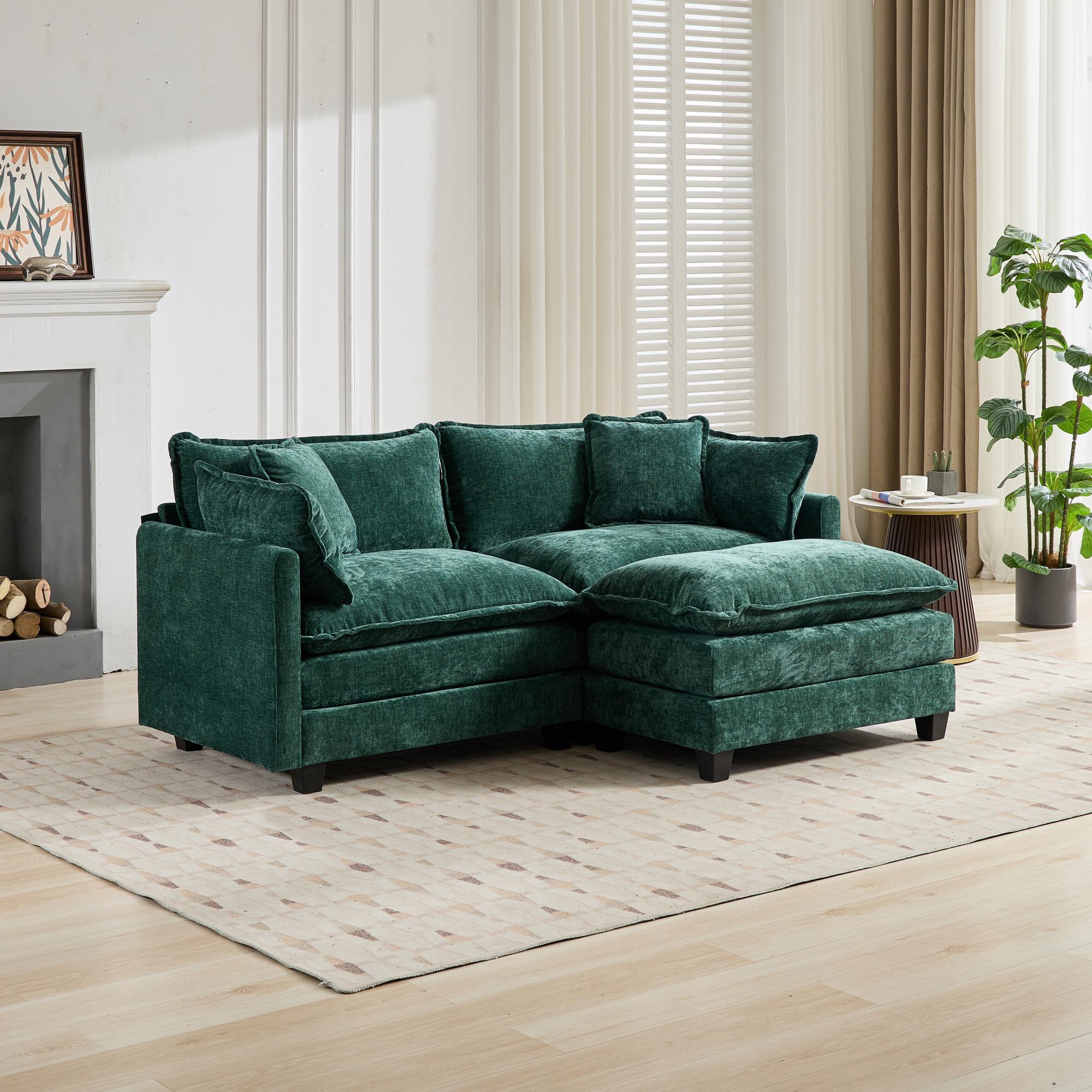 Green sectional sofa in a living room setting with a fireplace and plants.