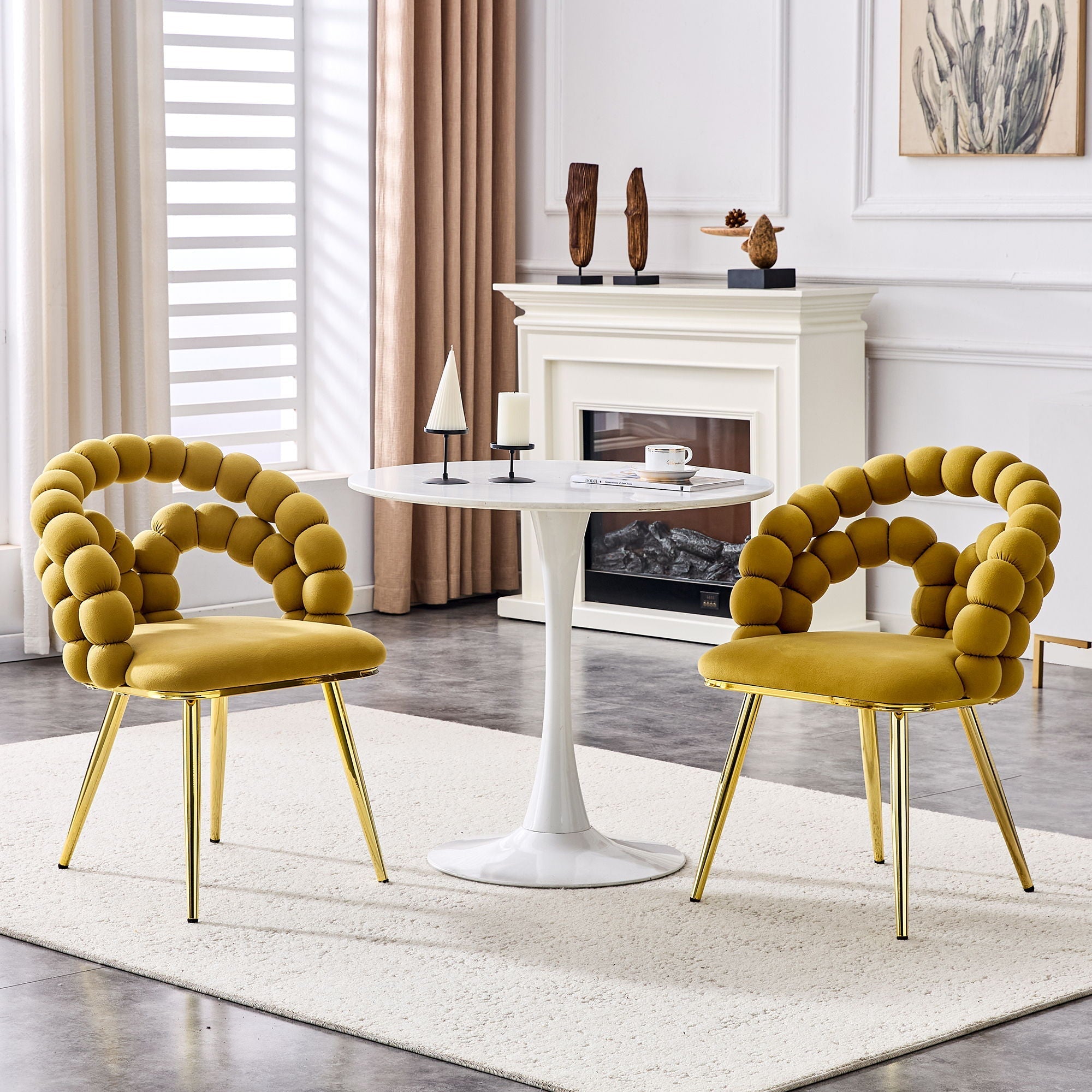 Two yellow chairs with gold legs in a living room setting.