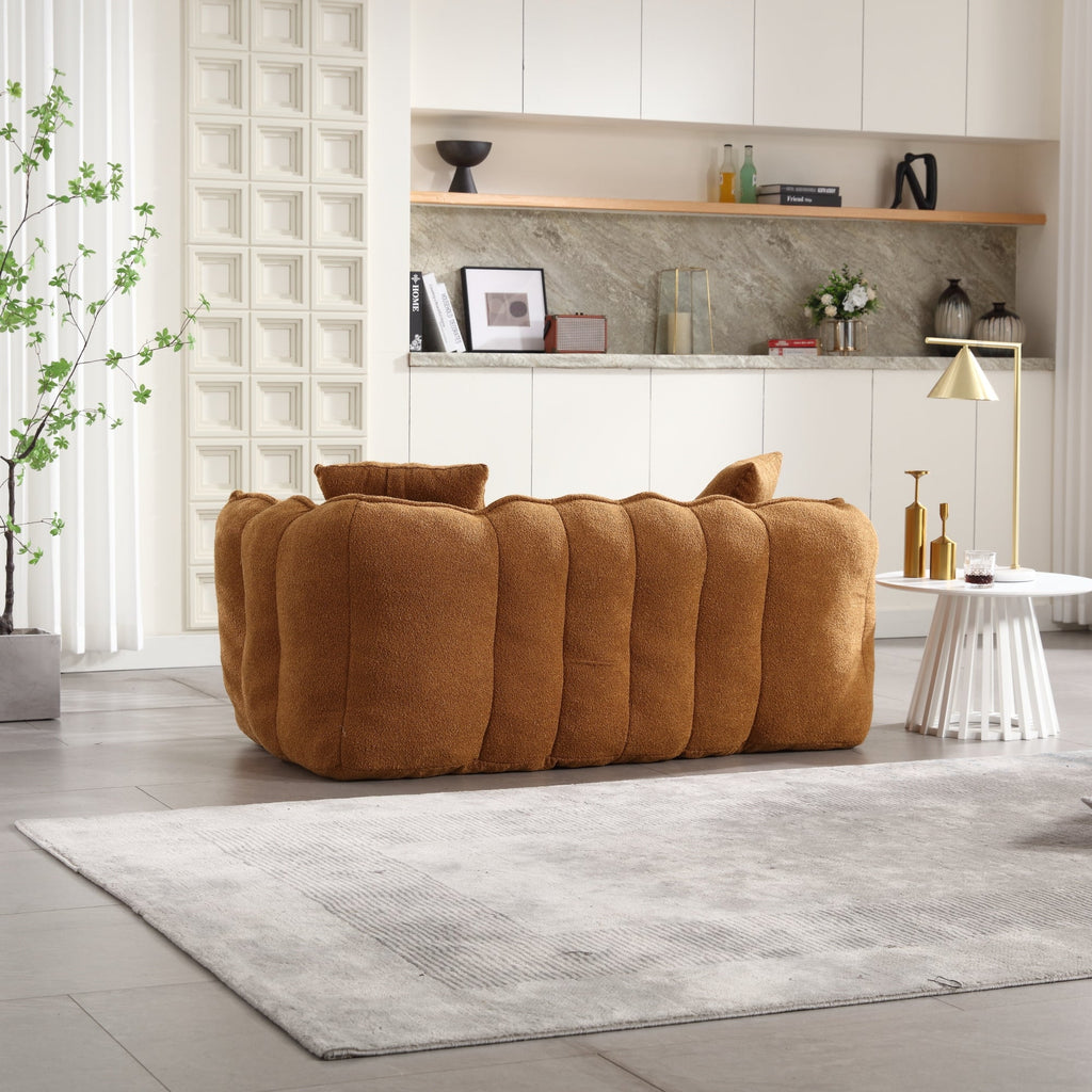 Brown sofa in a modern living room with a shelf and decor items.