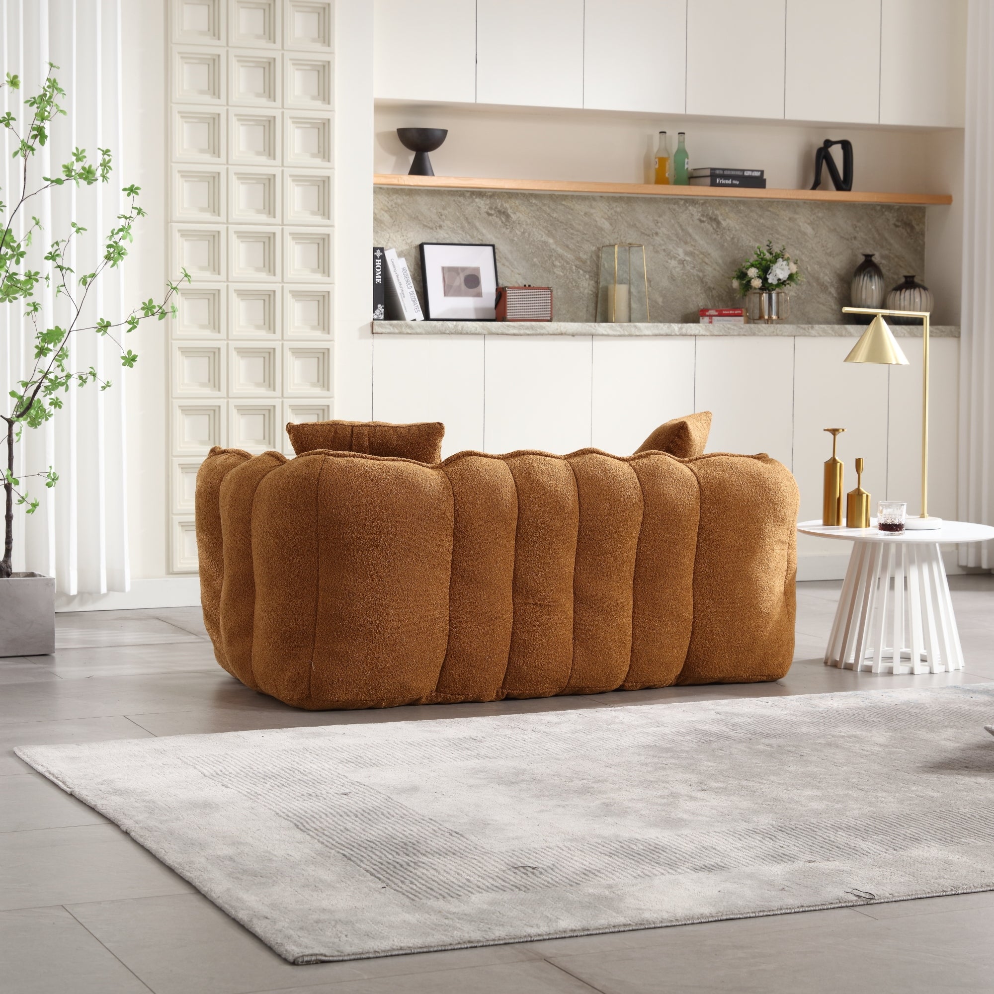 Brown sofa in a modern living room with a shelf and decor items.