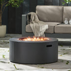Outdoor fire pit with flames on a patio, surrounded by a beige sofa and decorative elements.