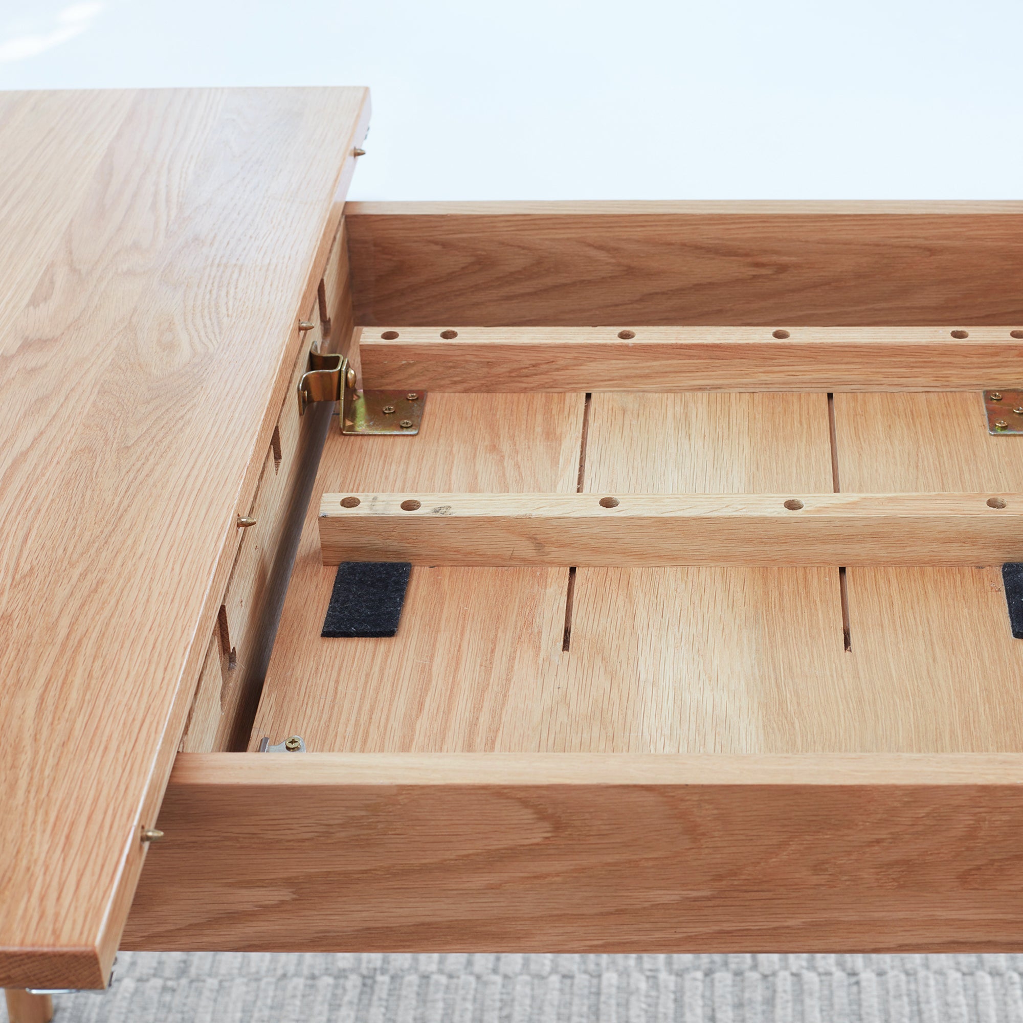 Wooden table with an open extension on a light gray surface