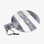 A round marble serving board with a handle and a dark brown leather drawstring, featuring diagonal white stripes over a blue-gray and white marble pattern, on a solid white background.
