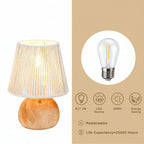 Table lamp with wooden base and white shade, featuring an LED bulb on a beige background.