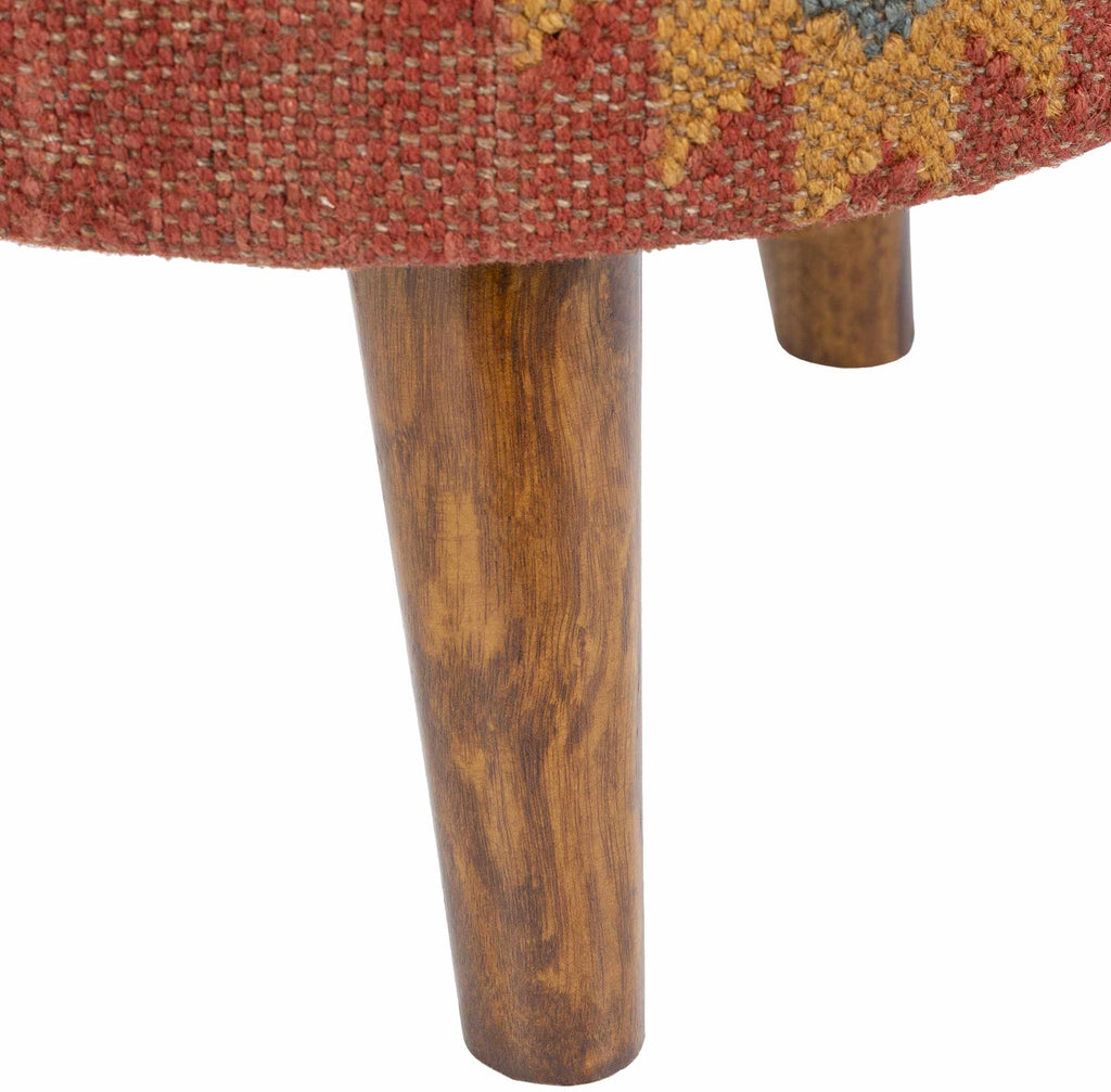 Close-up of a wooden leg of a chair with a colorful fabric seat.