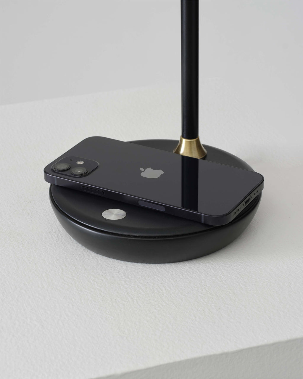 Black lamp with an Apple phone on a white background