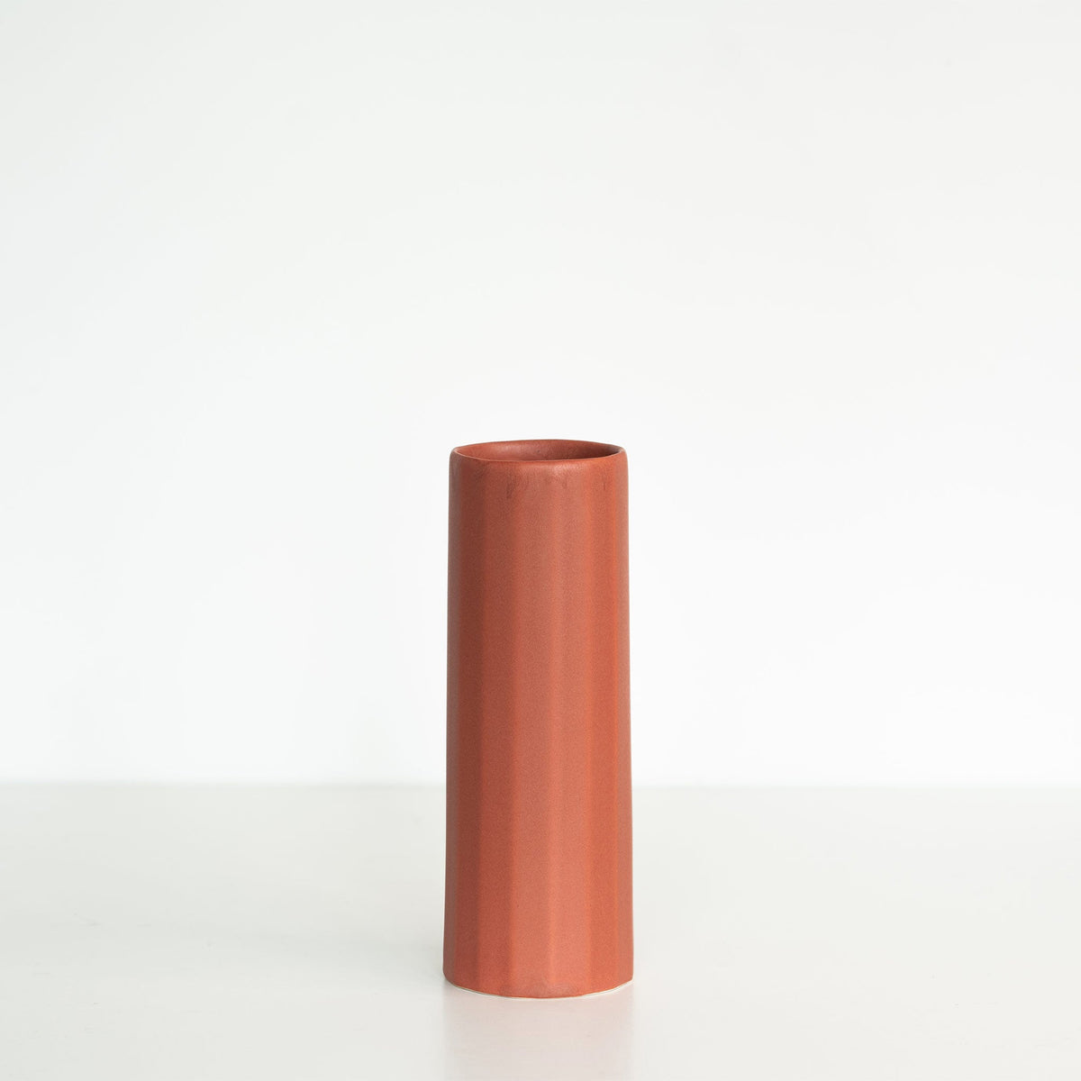 Cylindrical terracotta vase on a white background