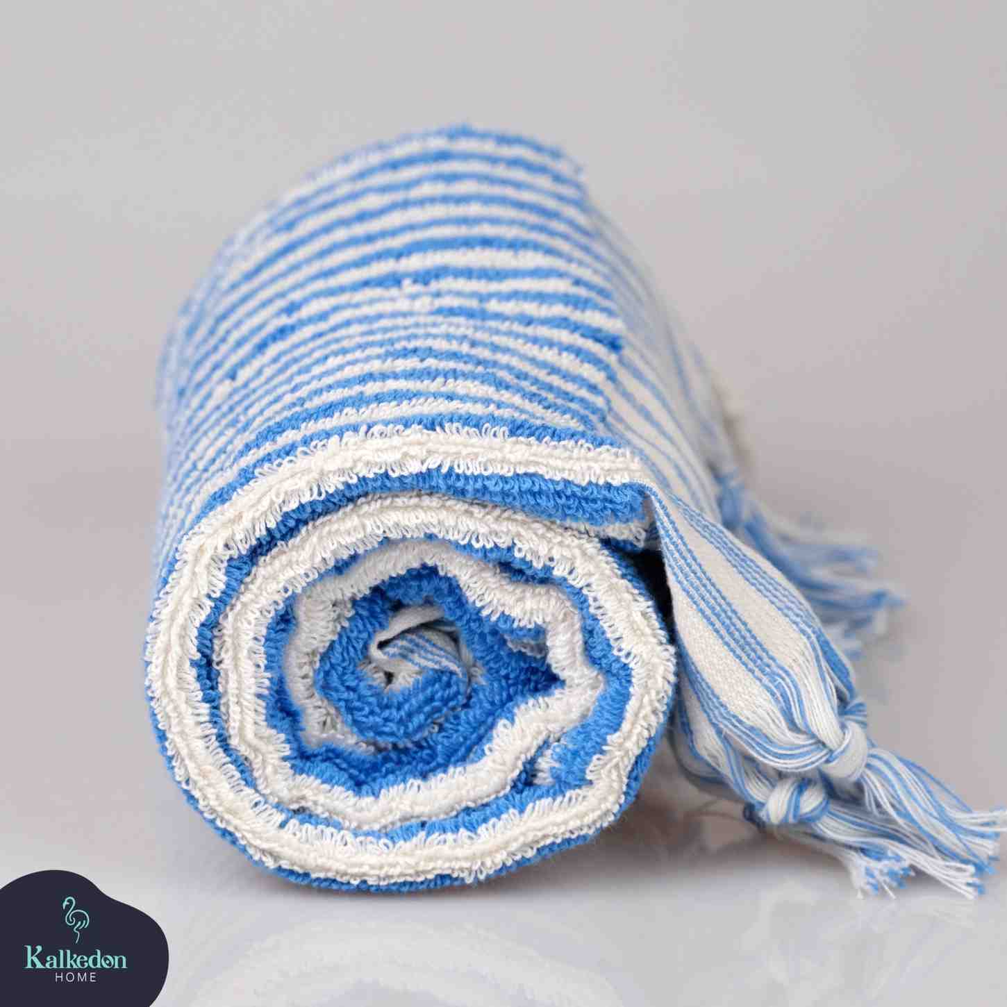 Rolled blue and white striped hand towel with fringed edge on plain background
