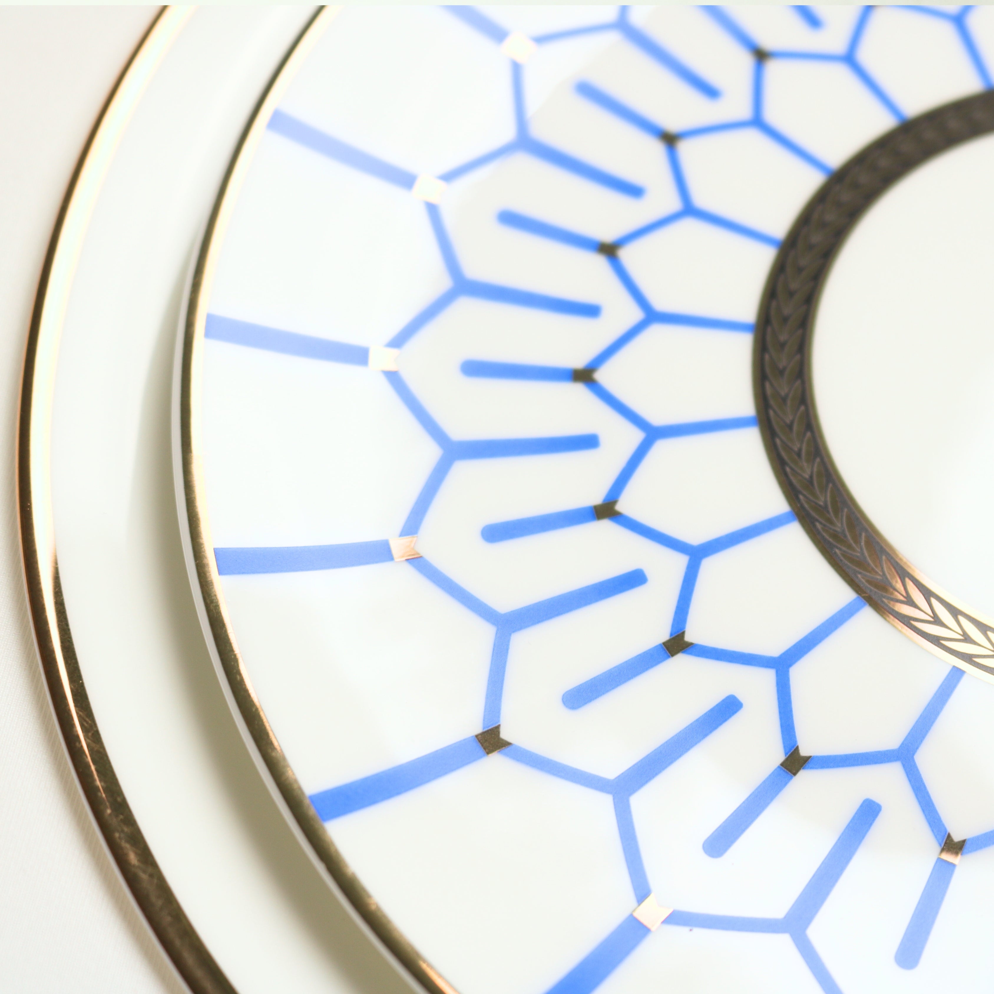 Ceramic plates with blue geometric pattern and gold trim on a white background